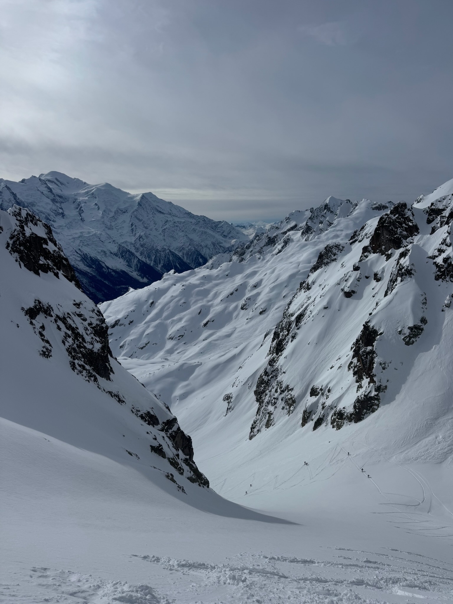 Looking down a steep snowy couloir from high on the ridge